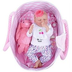 a baby doll is laying in a pink basket