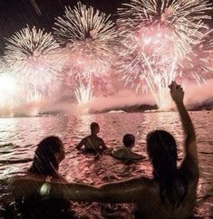 people are in the water watching fireworks