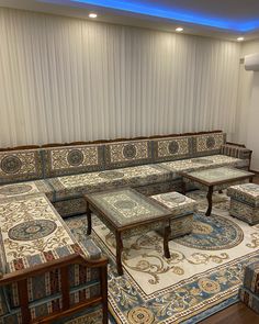 a living room filled with lots of couches and tables on top of rugs