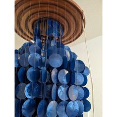 a chandelier made out of blue plates hanging from it's ceiling in a room