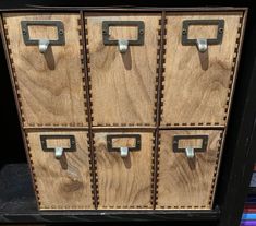 four wooden drawers with metal handles on them