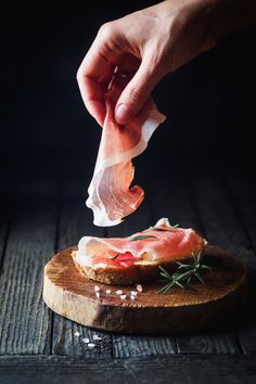 a person is sprinkling some meat on top of a piece of bread with salt and pepper