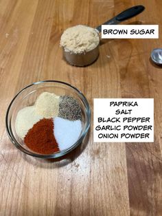 three different types of spices in small bowls on a wooden table with measuring spoons