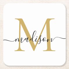 the letter m in black and gold on a white coaster that says madison with a handwritten font