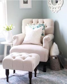 a chair and ottoman in a room with a mirror on the wall above it,