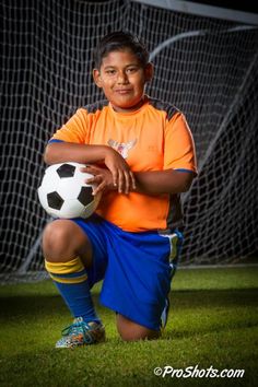 a young boy is holding a soccer ball