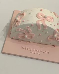 a birthday card with a tiara and bows on it's side, sitting on top of a table