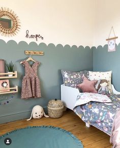 a child's bedroom with blue walls and wooden flooring, including a bed