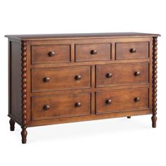 a wooden dresser with many drawers and knobs on the bottom drawer, against a white background