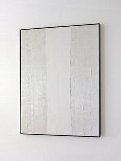 a white and black painting hanging on the wall