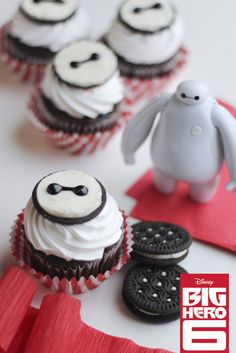 some cupcakes with frosting and decorations on them are displayed for the camera