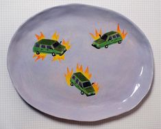 a plate with three cars on it and flames coming out of the back one is green