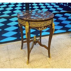 an ornately decorated table in front of a blue and black wall with geometric tiles