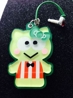 a green cat with a bow on it's head is attached to a lanyard