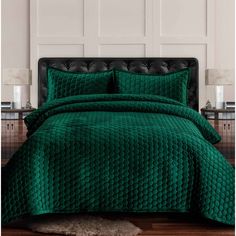 a bed with green comforters and pillows