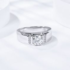 a white gold ring with a diamond set in the center and two diamonds on each side