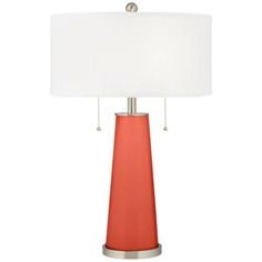 an orange table lamp with a white shade on the base and a silver metal base