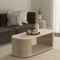 a living room with a couch, coffee table and two vases on the floor