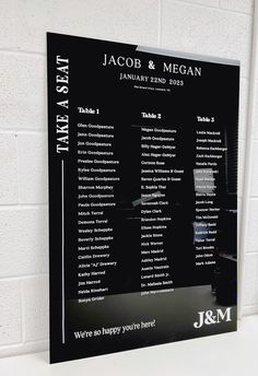 a black and white wedding seating chart hanging on a wall