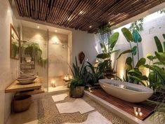 a bath room with a large tub surrounded by plants