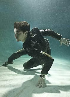 a man in black suit diving under water