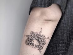 a woman's arm with a black and white tattoo design on the left forearm