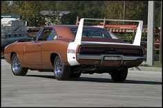 an orange and white muscle car parked in a parking lot