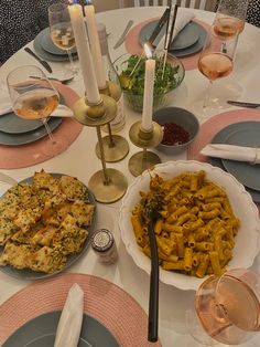 the table is set with pasta and wine