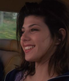 a woman smiling in the back seat of a car