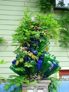 there are many blue glass bottles stacked on top of each other in the planter