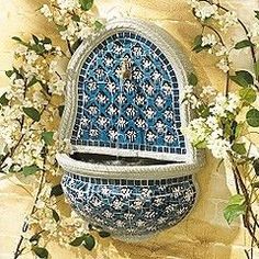 a blue and white vase with flowers on the outside is surrounded by branches that are blossoming