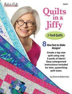 an older woman with glasses is holding quilts in her hands