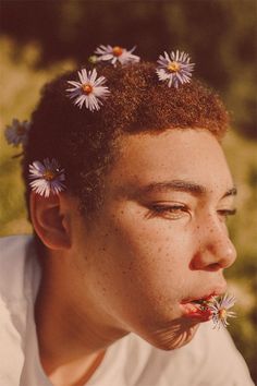 a young man with flowers in his hair