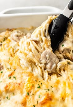 a spatula is being used to scoop pasta out of the casserole dish