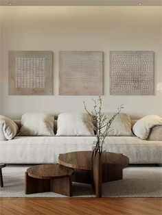 a living room filled with furniture and paintings on the wall above it's coffee table