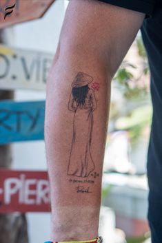 a person with a tattoo on their arm holding a skateboard and wearing a hat