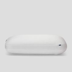 a white pillow sitting on top of a gray surface