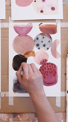 the person is painting different shapes on paper