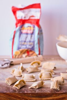 some kind of food that is on a wooden table next to a bag of chips