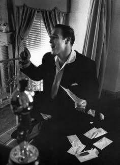 black and white photograph of a man sitting at a desk with papers in his hand