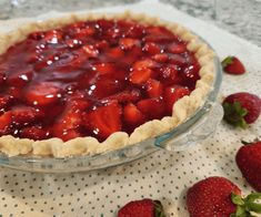 there is a pie with strawberries on the table