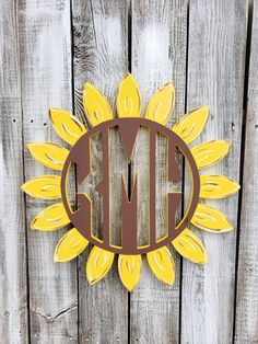 a sunflower monogrammed on the side of a wooden fence