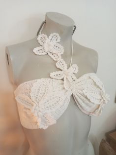 a mannequin wearing a white crochet bralet with flowers on it