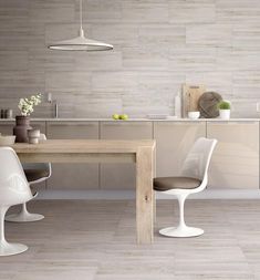 an image of a modern kitchen setting with white chairs and wood table in the background