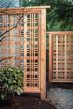 two wooden gates in the middle of a garden