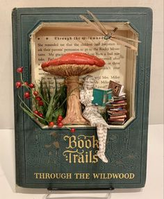 a miniature book with a toad sitting on top of a mushroom and surrounded by books