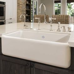 a large white sink in a kitchen next to a stove top oven and countertop