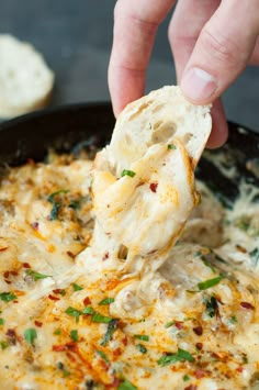 a person dipping some food into a skillet