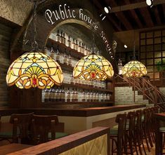 the interior of a bar with stained glass lamps hanging from the ceiling and wooden chairs