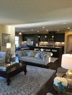 a living room filled with furniture next to a kitchen